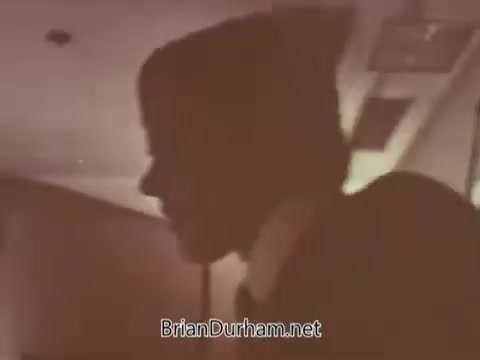 The still from the 'Radio Free Europe PSA' depicts a side profile of an individual, likely engaged in a discussion or presentation. The lighting is soft, creating a vintage atmosphere typical of 16mm film. The focus appears to be on the person's profile, emphasizing their expression and the seriousness of the context, which aligns with the message of the PSA.