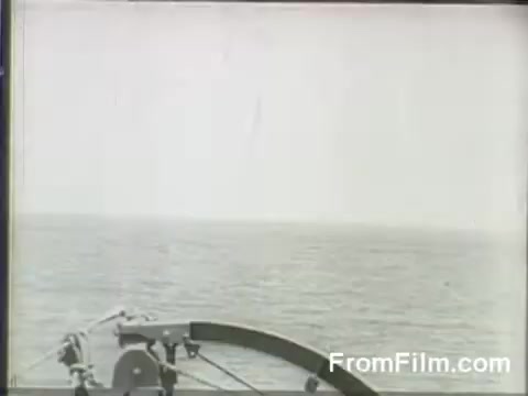 The still captures a view from the bow of the USS Hornet, with a vast expanse of ocean stretching out to the horizon. The atmosphere is likely tense and anticipatory, reflecting the historical moment of the Doolittle Raid on April 18, 1942, as B-25 bombers prepare for their launch. The scene evokes the military context of World War II, highlighting the naval operation involved in the raid.