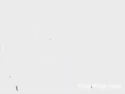 The still captures a moment from the Doolittle Raid, depicting B-25 bombers taking off from the USS Hornet on April 18, 1942. The image conveys a sense of urgency and action, emphasizing the significance of this daring air raid during World War II. The graininess and vintage aesthetic of the 16mm film format enhance its historical character.