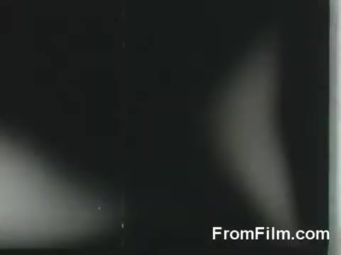 The still depicts a scene from the historical Doolittle Raid, showcasing the B-25 bombers preparing for launch from the USS Hornet on April 18, 1942. The image captures the intense moment of military readiness amid the backdrop of naval operations during World War II. The film grain and monochrome presentation enhance the vintage feel of the footage.