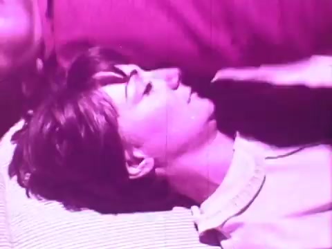 The still shows a woman lying comfortably on a mattress, her expression serene and relaxed. The image has a pink tint, suggesting a dreamy or nostalgic vibe. The focus is on her face, highlighting her comfort, which aligns with the theme of promoting the Beautyrest mattress's quality for restful sleep.