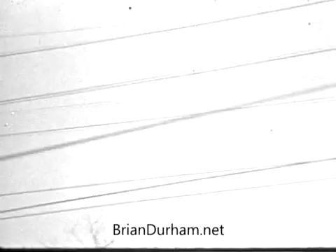 The 16mm still from the 'FTD Flower/gifts commercial' depicts a sky filled with numerous power lines. This imagery conveys a sense of connection and communication, aligning with the theme of sending floral gifts during significant celebrations like graduations and Mother's Day. The sparse background suggests a simple, yet effective representation of the occasion, emphasizing the idea of sending love despite physical distance.