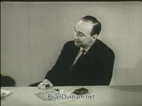 The still shows a man seated at a table, engaged in conversation. He has a thoughtful expression and appears to be discussing heart health, likely related to the message of the American Heart Association. The setting is simple, with minimal decor, emphasizing the serious nature of the topic.