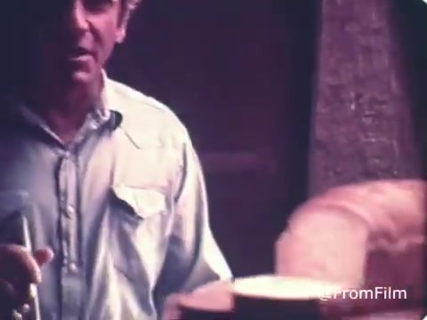 The still from the 1970s Roman Meal Bread commercial features a man in a light blue shirt, possibly in a baking or production environment. The focus appears to be on a loaf of bread, emphasizing the wholesome and artisanal qualities of Roman Meal’s whole-grain products. The atmosphere suggests a homey, authentic feel, typical of marketing from that era aimed at promoting healthy eating.