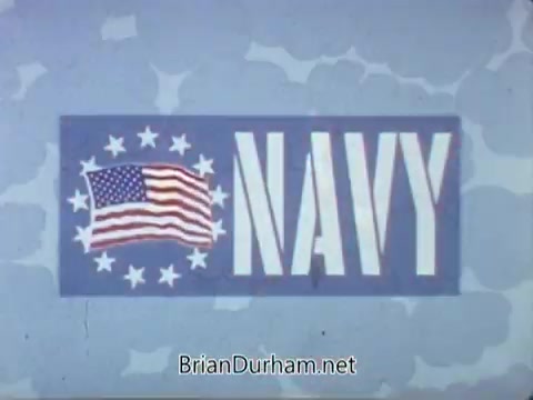 The still features a bold 'NAVY' text against a blue background, accompanied by a stylized American flag and a circle of white stars. The design exudes a patriotic theme, aiming to attract recruits. The overall aesthetic reflects the animation style typical of the late 1960s, emphasizing clarity and visual impact to convey a message of service and pride.