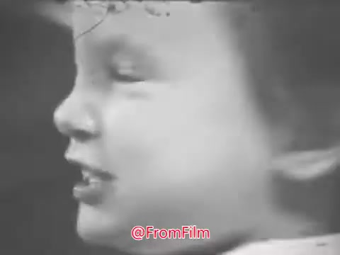 The still from the 16mm print of the 'Music Educators National Conference - 1969 PSA' features a close-up of a young child, likely in profile. The child appears to be engaged or expressive, capturing a candid moment that reflects a sense of joy or curiosity. The overall aesthetic aligns with vintage film characteristics, showcasing the historical context of the PSA from the late 1960s, promoting music education.  For more updates, follow @FromFilm on Twitter.