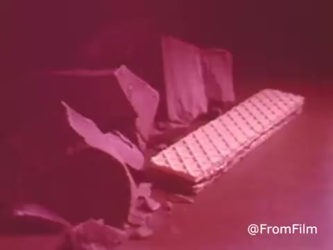 The still from 'Summit Cookie Bar - 1970's' likely showcases the product in a stylized or artistic format. It features a long, rectangular candy bar against a backdrop with muted colors, possibly highlighting the chocolate and wafer layers. The image may convey a nostalgic or retro aesthetic typical of advertising from that era, capturing the essence of the Summit Cookie Bar before it evolved into individual foil wrapping in 1983.