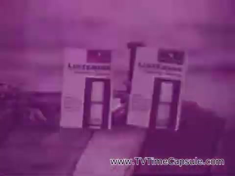 The still depicts two Listerine Breath Spray bottles prominently displayed against a blurred background. The color tone is predominantly purple, giving it a nostalgic vibe typical of a 16mm print. The packaging appears simple and functional, emphasizing the product's branding.