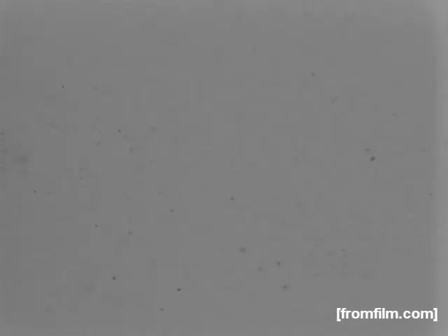 The still from 'High School Football - 1961' appears to be a blurred or poorly exposed image, lacking significant detail. It primarily showcases a faded gray background with some visible grain and speckles, indicating that it may have deteriorated over time. No specific action or scene from the football game is discernible in this frame.