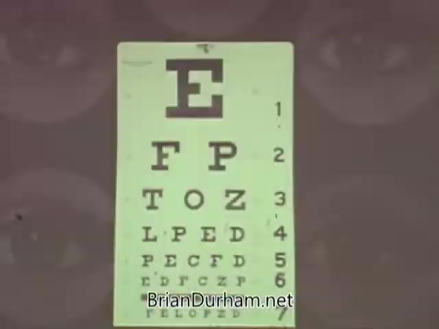 The still features a standard eye chart, prominently displaying the letter 'E' at the top, followed by a series of letters arranged in decreasing size, typically used for vision tests. The background may include partial images of eyes, emphasizing the focus on vision and eye care, consistent with the American Optometric Association's public service announcement themes from the 1960s.