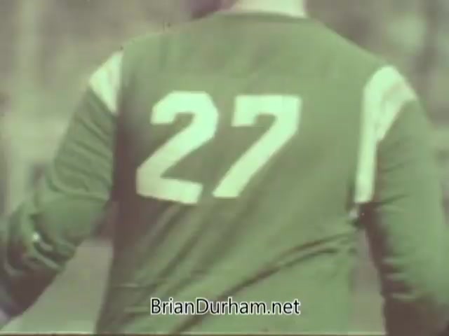 The still features a player wearing a green jersey with the number '27' prominently displayed on the back. The image appears to capture a moment during a sports event, likely emphasizing themes related to vision or eye health in the context of the American Optometric Association's public service announcement from the 1960s. The focus on the jersey suggests a connection to athletic performance and the importance of good eyesight in sports.