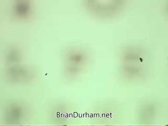 The still from the 'American Optometric Association PSA - 1960s' features a pale background with blurred shapes or patterns, possibly related to vision testing. The image may highlight the importance of eye care, typical of public service announcements from that era, focusing on vision health awareness.