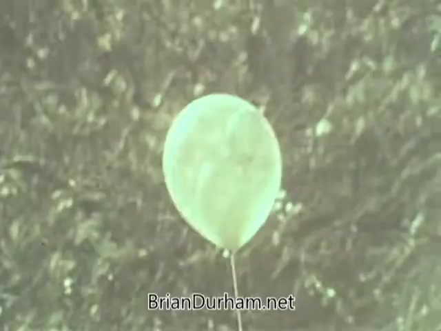 The still shows a single, light-colored balloon floating against a blurred, indistinct background. The image appears washed out, typical of 1960s film quality, and conveys a simple, nostalgic atmosphere. It may relate to a public service announcement by the American Optometric Association, potentially emphasizing vision-related themes or awareness.