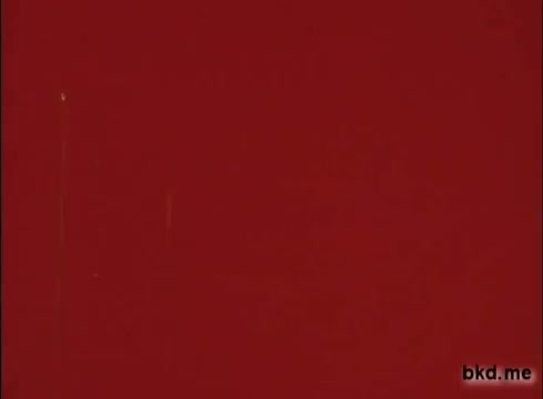 The still from the 'Clorox TV Commercial - 1970's' features a solid red background. The surface shows signs of wear, with scratches and imperfections typical of a 16mm print, adding a vintage texture to the image. There are no other notable elements present in the frame.