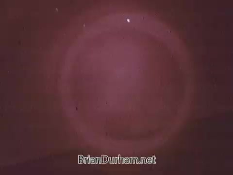 The still from the 1968 Dove Soap commercial features a soft, diffuse background with a circular, glowing effect. The colors appear warm hues—likely shades of brown or pink—creating a gentle, inviting atmosphere. The overall aesthetic suggests a focus on purity and softness, in line with Dove's branding as a gentle skincare product. The image has a vintage quality typical of media from that era.