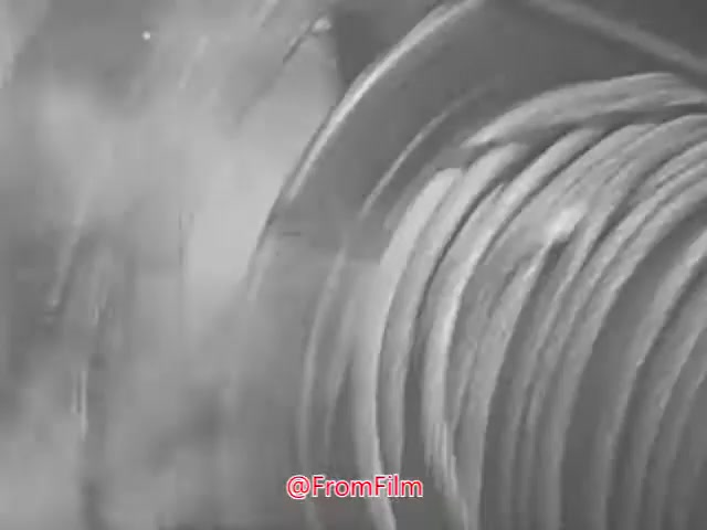 The still from 'Project CARE PSA - 1960s' features a close-up view of what appears to be a coiled object, possibly a hose or cable. The image is characterized by a monochrome palette with a soft focus, creating a somewhat hazy and textured appearance. This visual style is typical of 16mm film, giving it a nostalgic and retro quality. The context suggests a public service announcement, likely aimed at promoting awareness or education on a specific topic relevant to that era.