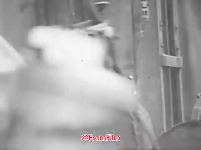 The still from 'Project CARE PSA - 1960's' captures a black-and-white moment likely depicting a scene related to a public service announcement. The frame suggests movement, possibly featuring people interacting with their environment, such as a doorway or a vehicle. The style reflects the aesthetics of 1960s film, emphasizing a docu-drama feel typical of that era's PSAs. The image seems to promote a communal message, aligning with the goals of Project CARE.