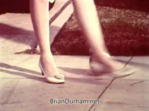 The still from the 'National Safety Council PSA' features a close-up of a woman’s legs walking on a sidewalk. She is wearing high-heeled shoes and appears to be in motion. The scene likely emphasizes safety, possibly in relation to pedestrian awareness.