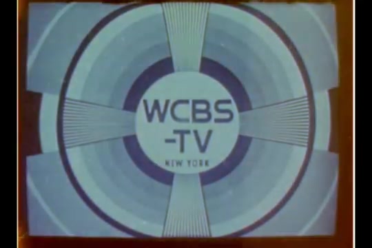 The still features the logo of WCBS-TV, which is presented in a simple, circular design typical of the 1970s. The logo is centrally positioned, with 'WCBS' prominently displayed above 'TV' and 'NEW YORK' below, all set against a light blue background with radial patterns. The overall aesthetic reflects the graphic style of broadcast television from that era.