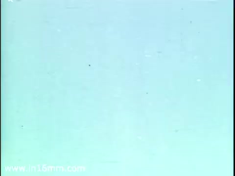 The still from the 1975 Christmas Seal PSA features a soft, light blue background with subtle texture, likely indicative of aging in the 16mm film print. It captures the essence of mid-20th century public service announcements, potentially aiming to raise awareness about respiratory health and the importance of Christmas Seals in fundraising efforts.   As for the usage of Christmas Seals today, many people, including older generations like grandmas, might still remember them, but their popularity has waned over the years.