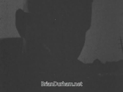 The still from the 'Jerry Lewis Muscular Dystrophy PSA' features a silhouette of a man, possibly Arnold Hughes, laboring in the sun. His expression suggests pride in his strength and effort as he works, reflecting his dedication to providing for his family. The emotional weight of his thoughts about his son, Spunky Hughes, who has muscular dystrophy, adds depth to the imagery, highlighting the contrast between his physical capabilities and the challenges his son faces. The overall tone evokes a mix of determination and compassion.