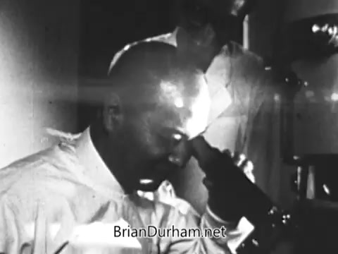 The still from the 'Jerry Lewis Muscular Dystrophy PSA' captures a moment of introspection, likely depicting Arnold Hughes, a devoted father, absorbed in thought as he contemplates the struggles of his son, Spunky, who lives with muscular dystrophy. The emotional weight of his responsibility is emphasized by the contrast between his physical strength in labor and his son's limitations. The ambiance suggests a mix of determination and sadness, underscoring the personal impact of the disease on their family.