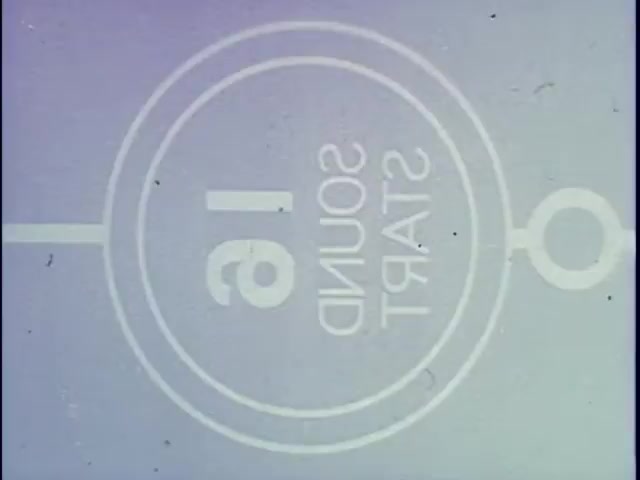 The still features a vintage film leader from a 16mm print, showcasing a simple graphic design. The text '16 SOUND START' is prominently displayed, indicating the film's format and sound capabilities. The circular border and clean typography evoke a nostalgic aesthetic, characteristic of classic film footage. The overall color palette is muted, reflecting the age and style of 16mm film. This image effectively captures the essence of traditional filmmaking and serves as an introduction to a film segment.