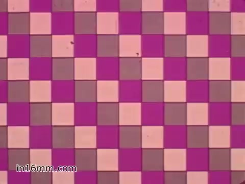 The still displays a visually striking pattern of squares in alternating shades of pink, white, and gray. The colors create a retro, eye-catching checkerboard effect typical of design styles from the 1960s, fitting the era of the West Virginia Safety Council PSA focused on vehicle safety. The composition reflects a playful yet serious tone, aligning with public service announcements that aim to capture attention while conveying important messages.