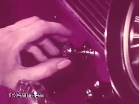 The still from the 1960s PSA by the West Virginia Safety Council shows a close-up of a hand reaching towards a vehicle's ignition switch. The scene is characterized by a vintage aesthetic, featuring muted colors. The focus on this action emphasizes the importance of vehicle safety and proper vehicle operation as part of the public service message.