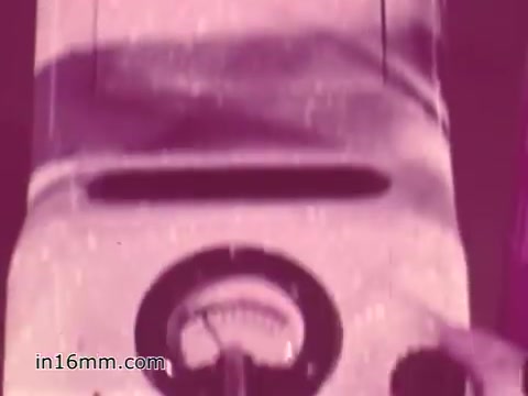 The still from the 'West Virginia Safety Council PSA' showcases a close-up of a dashboard or device related to vehicle safety, likely a gauge indicating some aspect of vehicle performance or inspection. The colors appear muted with a vintage quality typical of 1960s film, giving it a historical context. This visual element aims to underscore the importance of vehicle safety checks in public awareness campaigns.