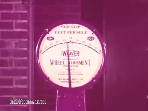 The still depicts a vintage wheel alignment gauge labeled 'Weaver,' showcasing a dial measuring 'side slip' in 'feet per mile.' The gauge is likely part of a public service announcement focused on vehicle safety and maintenance from the 1960s, emphasizing the importance of proper vehicle alignment for safe driving. The coloration suggests a vintage, possibly washed-out appearance typical of 16mm film prints from that era.