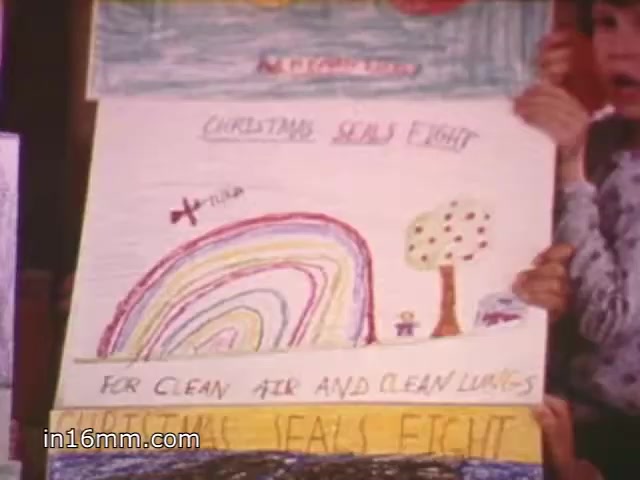 The 16mm still from the 'Christmas Seals 1981 PSA' features a colorful, child-like drawing held by a child. The artwork includes a rainbow, a tree, and figures near the bottom. The text emphasizes the theme of 'FOR CLEAN AIR AND CLEAN LUNGS,' promoting the Christmas Seals campaign. The vibrant and innocent style reflects a message of hope and environmental awareness.