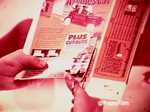 The still from the 1960s Archies Alpha Bits commercial shows a hand holding a cereal box, highlighting a promotional cutout for the 'Archies car.' The vibrant colors and playful design reflect the era's marketing style aimed at children, emphasizing the fun and interactive elements of the Alpha Bits cereal experience.