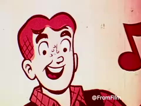 The still features a vibrant cartoon depiction of Archie, characterized by his signature red hair and cheerful expression. He is likely promoting Post Alpha Bits cereal, which ties into the playful and nostalgic vibe of the 1960s. Musical notes may be present, suggesting a catchy jingle associated with the commercial. The colors are bright and bold, typical of animated advertisements from that era.