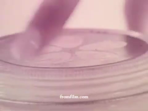 The still features a close-up of a jar of Kibon mayonnaise, showcasing a hand delicately holding the lid. The soft, muted color palette typical of the 1970s adds a nostalgic touch. The focus is on the jar's details, emphasizing its design and branding while hinting at the product's creamy texture. The overall aesthetic reflects the advertising style of that era, aiming for a warm and inviting feel.