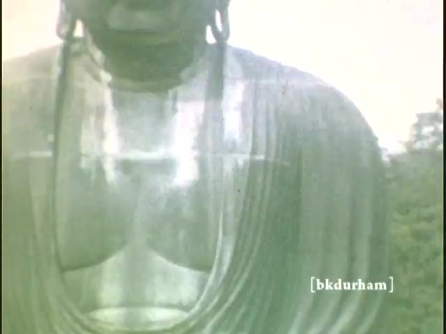 The still captures a close-up view of the Great Buddha (Daibutsu) in Kamakura, Japan, from a 16mm home movie shot between 1959 and 1960. The image focuses on the statue's upper body, highlighting its serene expression and intricate details of the robes. The muted colors evoke a nostalgic feel, characteristic of the era's film stock. This moment is a personal glimpse into history, reflecting the significance of the Buddha as a cultural icon.   For more, follow us on Twitter @FromFilm or like and subscribe on YouTube.