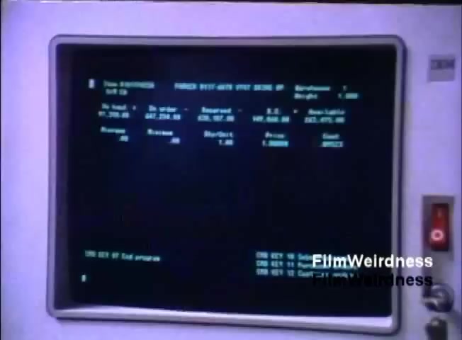 The still features a vintage computer monitor displaying a green-on-black interface typical of the 1980s. The screen shows what appears to be a data management or order processing system, with fields detailing item numbers, descriptions, quantities, and prices. The IBM logo is visible on the monitor, indicating the context is related to the IBM System 36 sales film from 1984. Controls and buttons are visible on the side of the monitor. The overall aesthetic reflects the technology of that era.