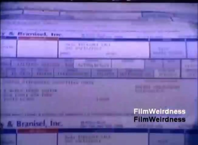 The still from the IBM System 36 sales film showcases a close-up view of printed documents or data entries. The content appears to feature tables with various fields and numbers, indicative of business or inventory records. The layout suggests a focus on functionality, highlighting the system's data processing capabilities prevalent in 1984. The image conveys a sense of technology and data management typical of that era.