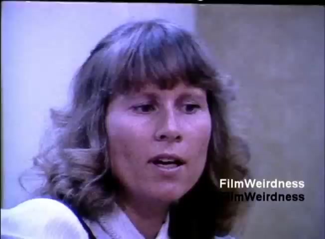 The still features a woman with medium-length, curly hair, captured while speaking. The setting appears to be a professional environment, suggesting a discussion or presentation related to the IBM System 36. The visual style reflects the 1980s, with natural lighting and a focus on the subject.