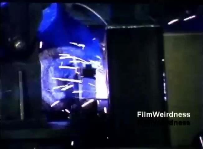 The still features a close-up shot of a welding process, capturing bright sparks and a blue glow. This scene likely emphasizes the industrial and technological aspects related to the manufacturing of the IBM System 36, showcasing the precision and innovation involved in its production. The composition conveys energy and dynamism, fitting the context of a sales film aimed at promoting IBM's technological prowess.