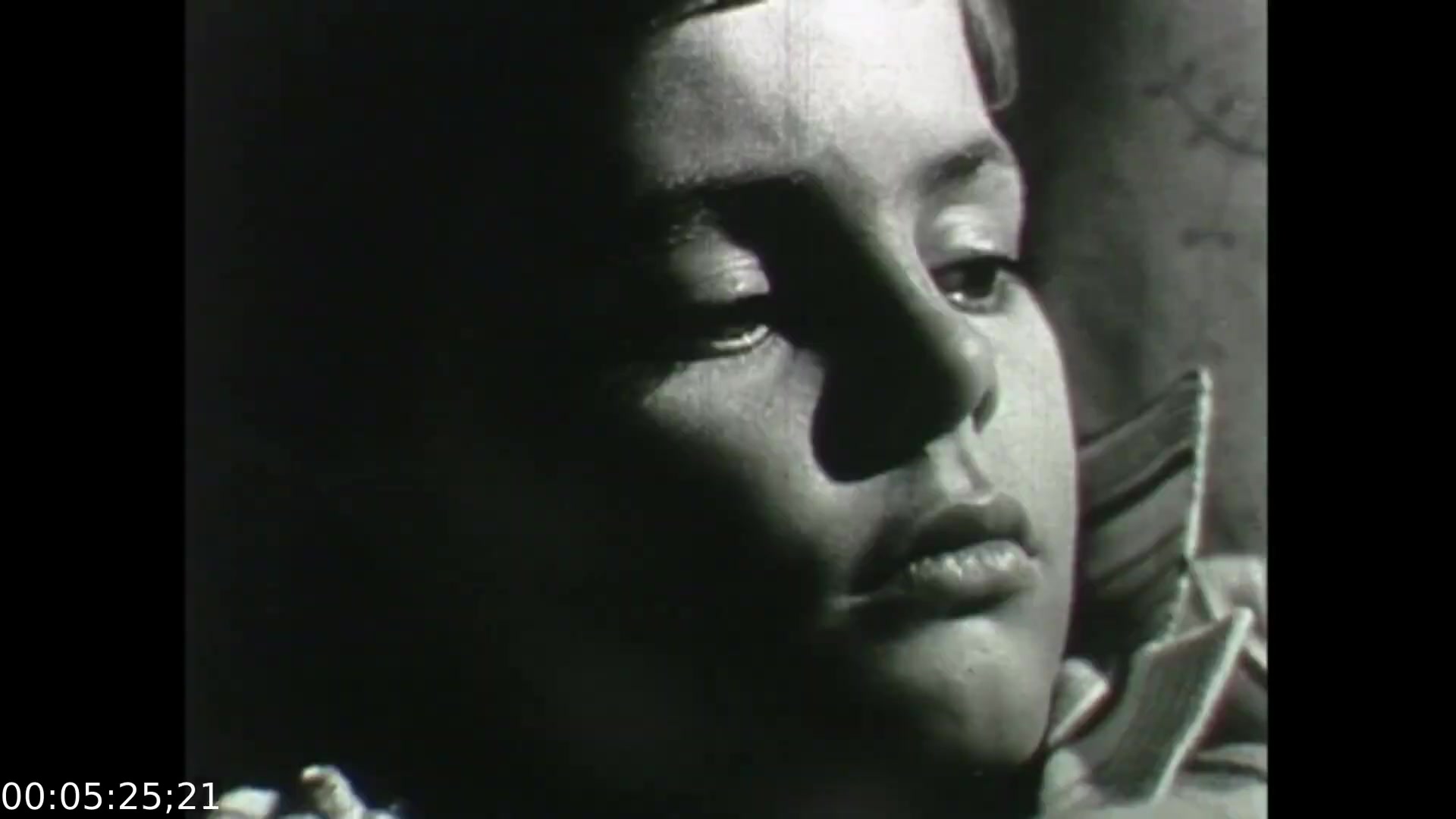 The still from 'Feelings of Depression' presents a close-up of a young boy, evoking a sense of melancholy. His expression is contemplative, with half-closed eyes and a solemn demeanor, suggesting inner turmoil. The black-and-white format enhances the emotional weight of the scene, aligning with the film's exploration of depression through the narrative of John Murray, emphasizing the profound impact of psychological struggles. This moment captures the film’s aim to educate viewers on the complexities of mental health.