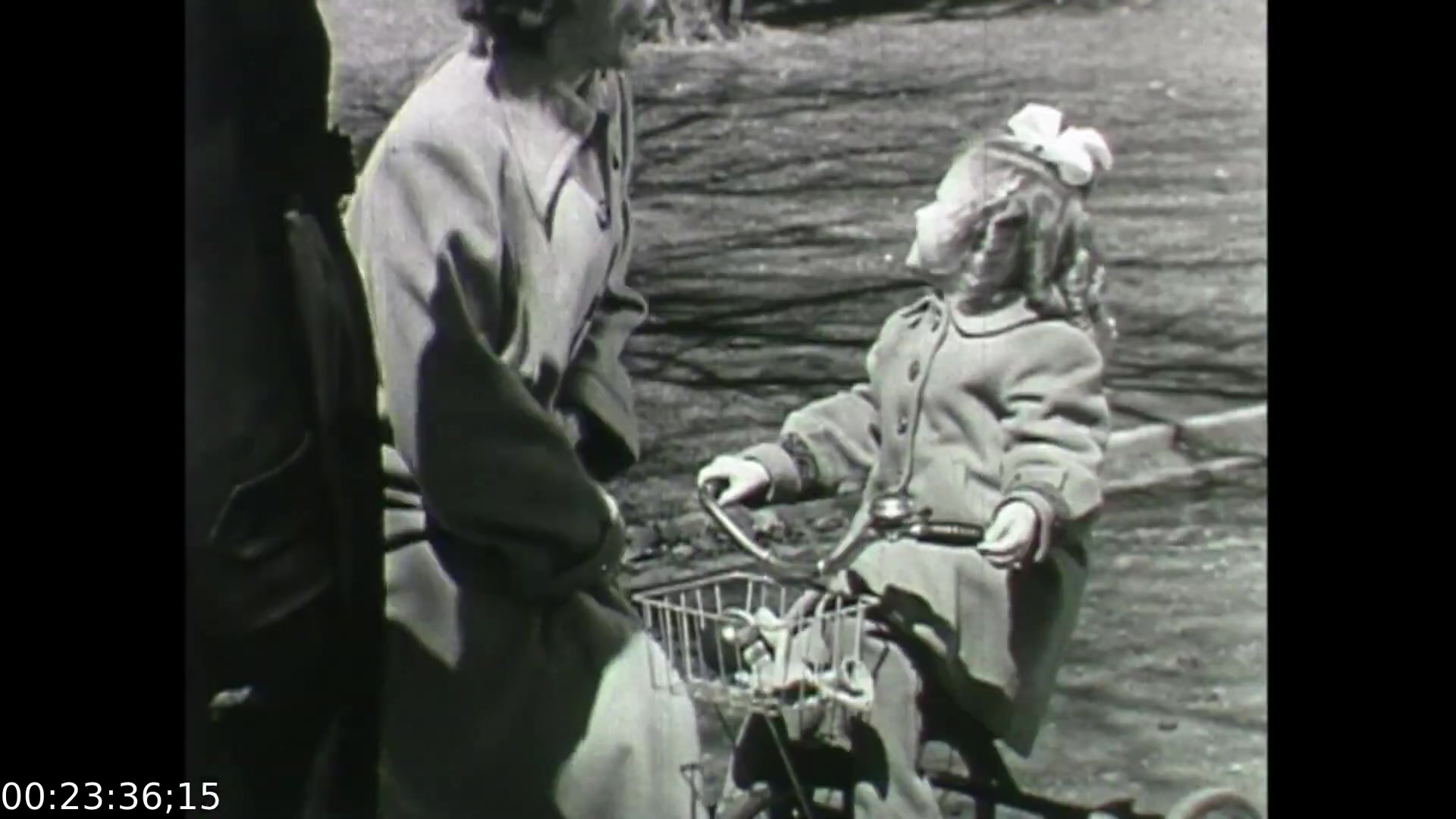 The still from 'Feelings of Depression' shows a woman conversing with a young girl on a tricycle in a park. The woman appears to be engaged and attentive, while the girl, dressed warmly, is looking up, perhaps responding to the conversation. This scene emphasizes the supportive relationships and everyday life moments that can influence mental health, a key theme of the film which addresses the emotional struggles of the protagonist, John Murray. The film aims to raise awareness about depression and suggests the importance of social connections in coping with mental health issues.
